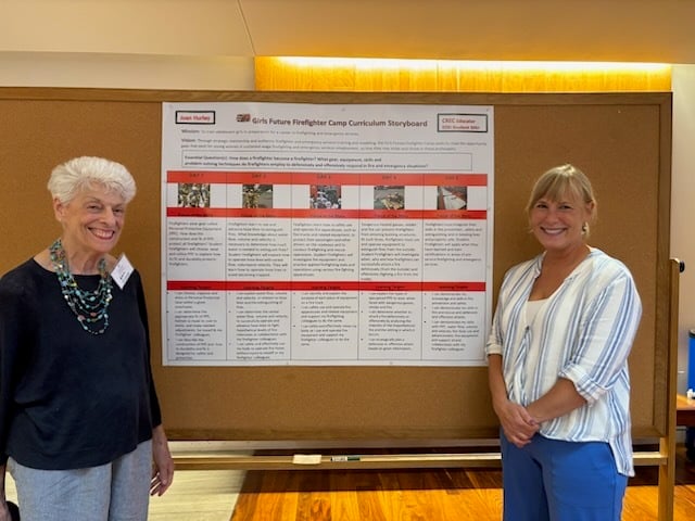 two women standing in front of storyboard