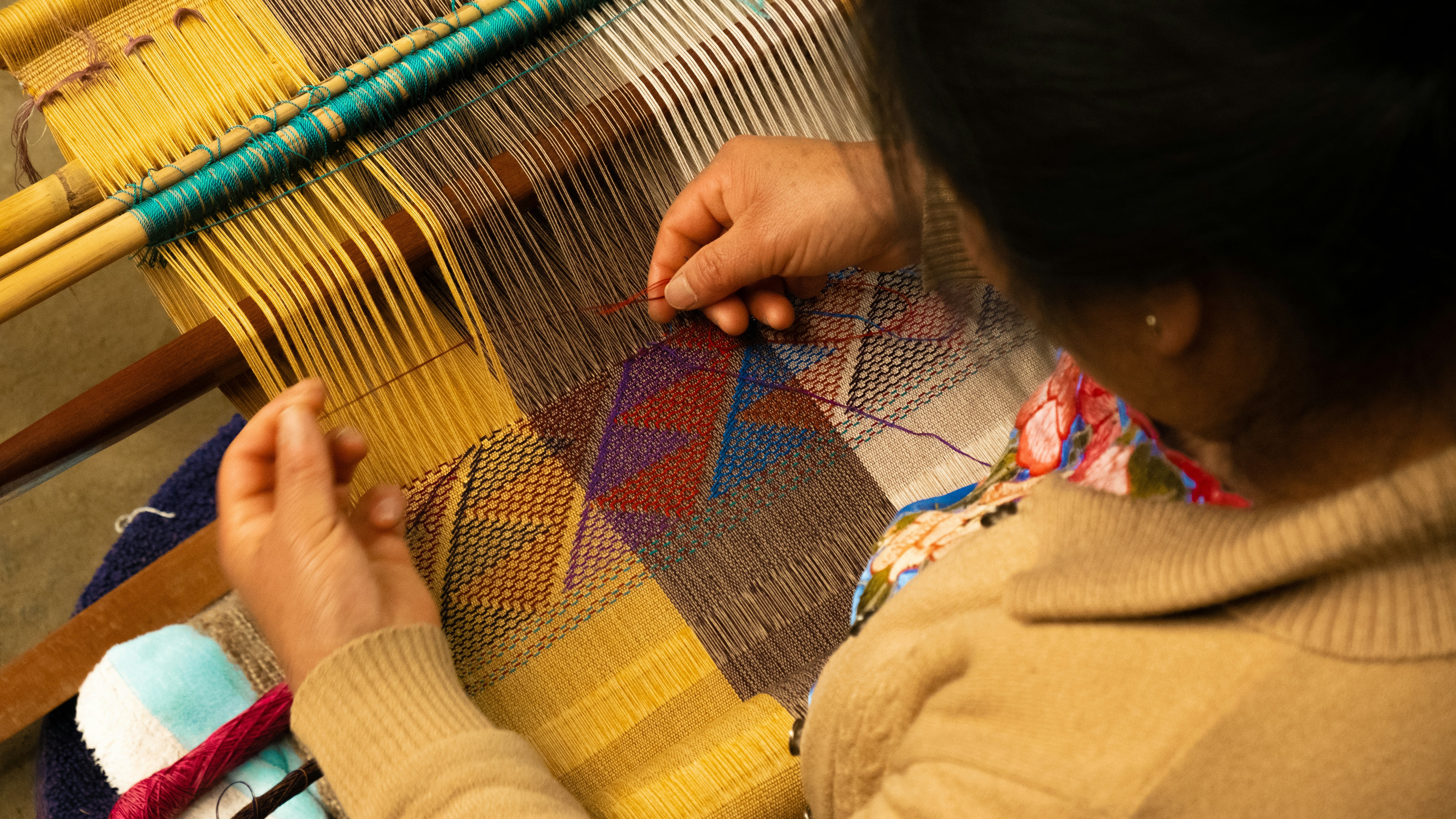 woman weaving a tapestry